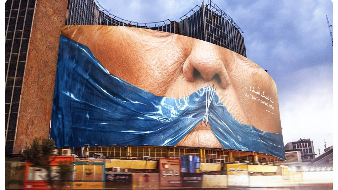Mural raksasa di Teheran, Iran, menampilkan wajah Presiden AS Donald Trump dengan mulut yang ditutup oleh ilustrasi Selat Hormuz