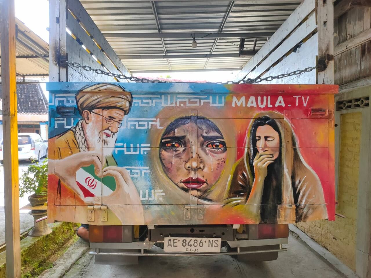 Mural bergambar Syahid Ayatullah Sayyid Ali Khamenei, simbol persatuan Iran-Palestina, dan ilustrasi korban perang menghiasi bagian belakang kendaraan yang digunakan dalam aksi kreatif Maula TV di Indonesia.