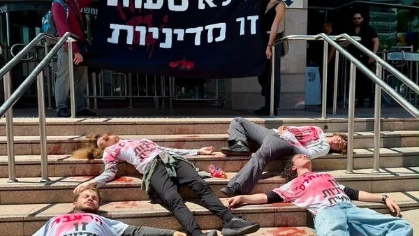Anggota partai Hadash berbaring dengan tubuh dilumuri warna merah dalam aksi protes di depan kompleks pemerintahan Tel Aviv, menentang kejahatan Israel terhadap warga Palestina di Gaza dan Tepi Barat.
