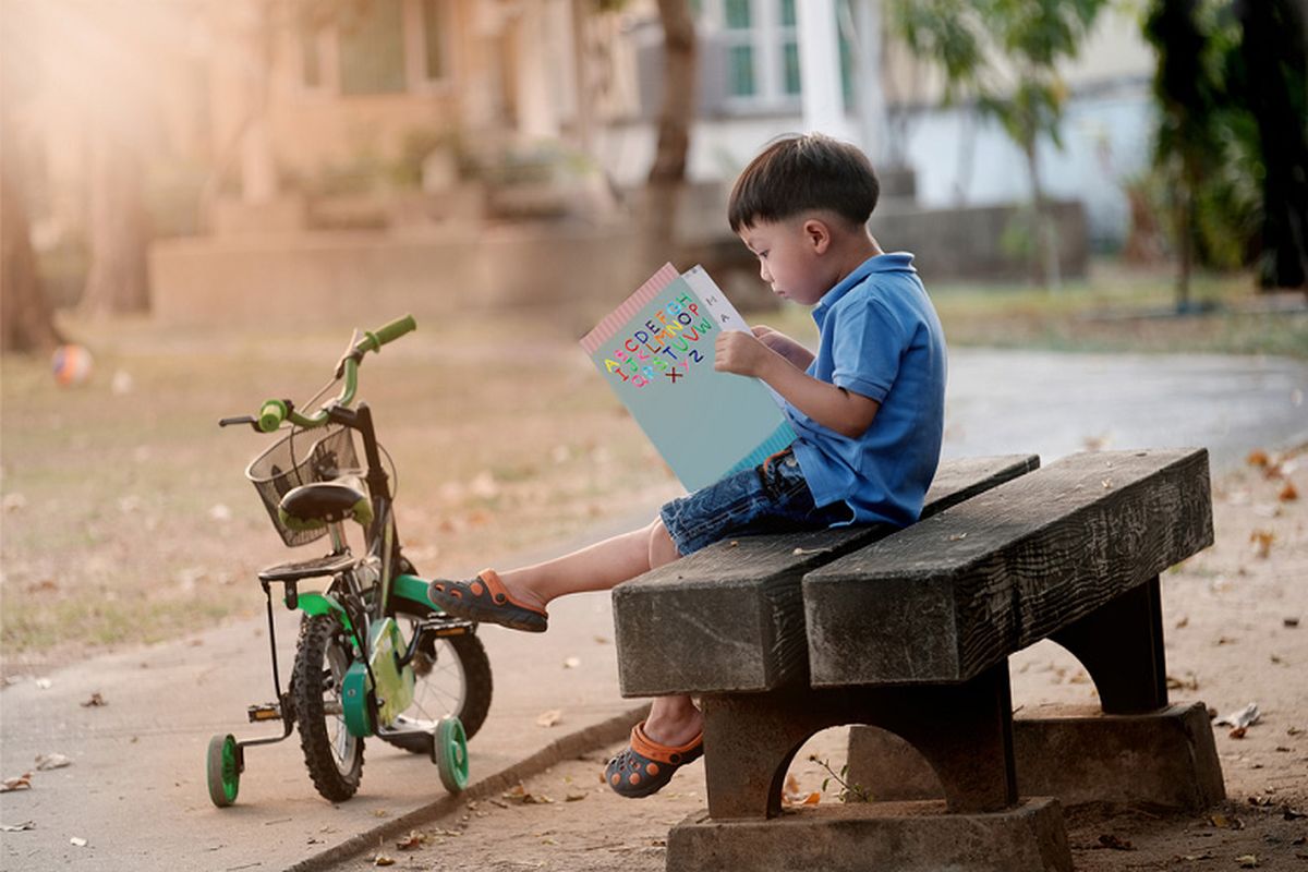 Anak tidak harus lancar membaca untuk mencintai cerita. Luangkan waktu untuk membacakan buku dan menemani mereka mengenal dunia. (Ilustrasi anak sedang membaca buku. Shutterstock/Issaret Yatsomboon)